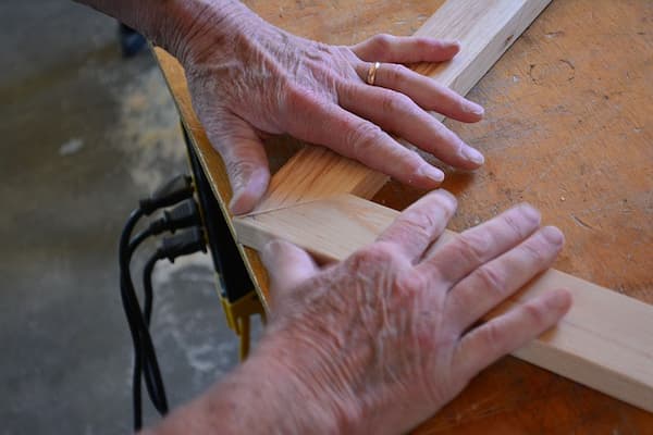 1 Prelucrarea lemnului - mainile unui tamplar fixeaza doua profile din lemn